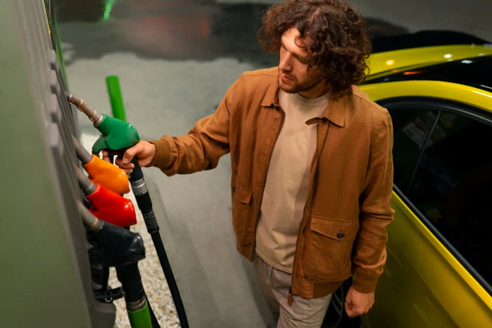 hombre poniendo combustible a su coche